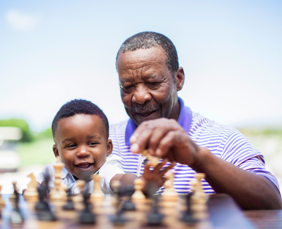 Man and child playing chess outdoors, featured in Viatris Global Healthcare Gateway section on global medicine access.