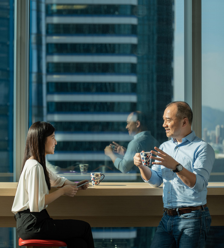 Viatris culture with two employees talking by office window, highlighting collaboration and core values.